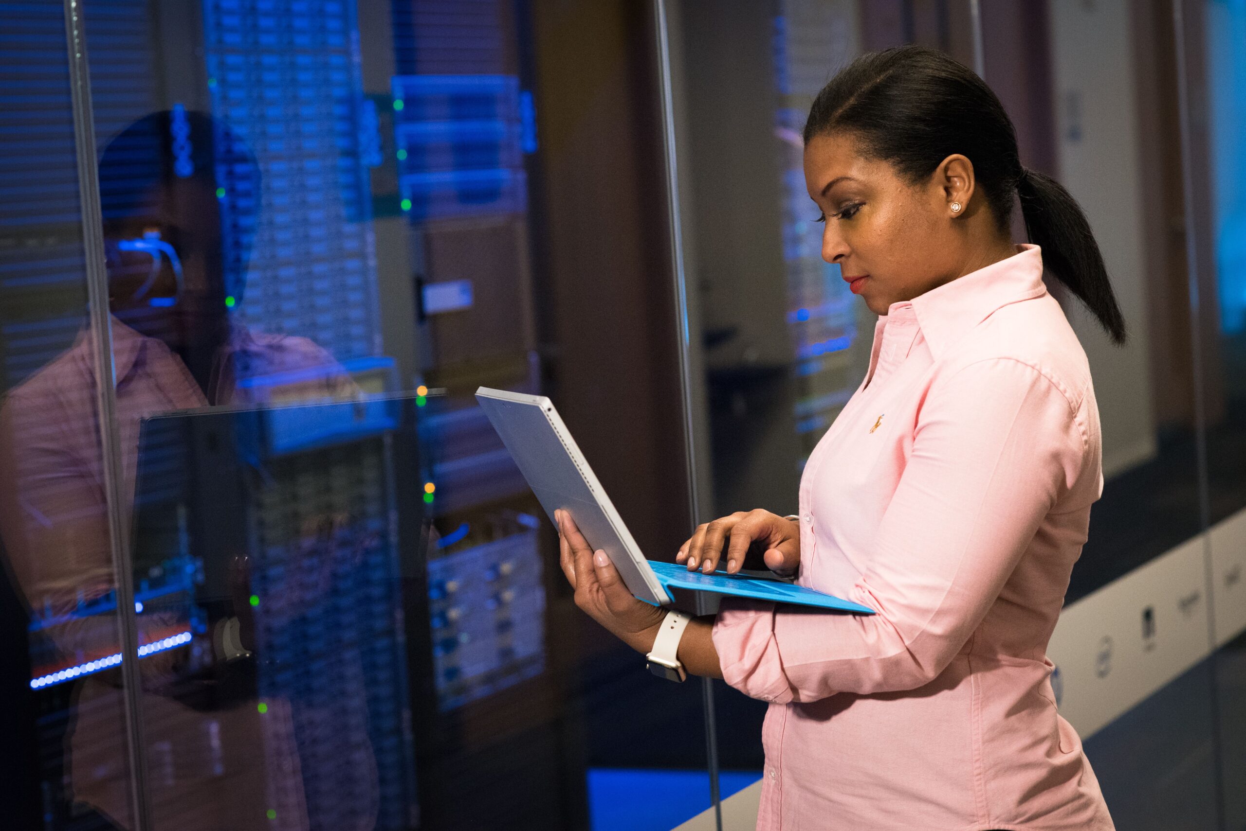 Engineer monitoring a Kubernetes cluster dashboard managing AI workloads on multiple screens