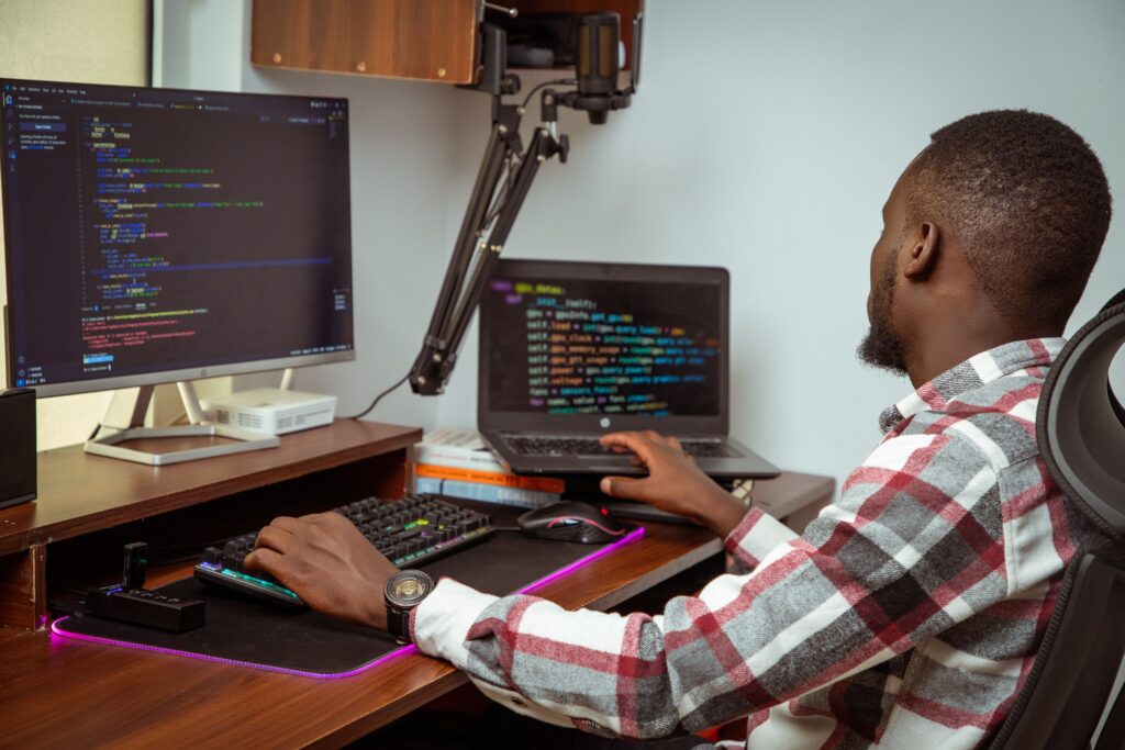 Developer reviewing AI-generated code suggestions on a laptop in a busy workspace